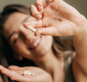Woman holding a pill with text about magnesium supplement intake.